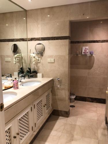 een badkamer met een wastafel en een spiegel bij Beachside Luxury 2 bedroom apartment, Puerto Banus in Marbella
