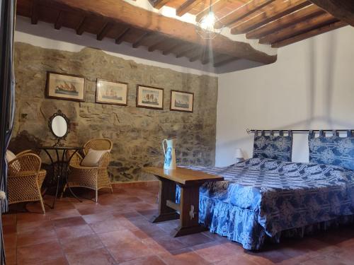 a bedroom with a bed and a table and chairs at Il Fico di Cortona in Cortona