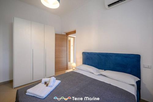 een slaapkamer met een groot bed met een blauw hoofdeinde bij Nettuno, TerreMarine in Monterosso al Mare