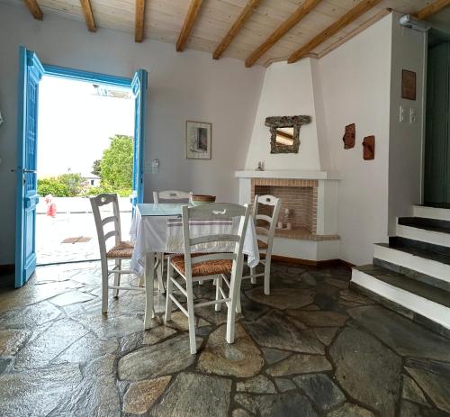 a dining room with a table and chairs and a fireplace at ELECTRA TRADITIONAL HOUSE in Alonnisos
