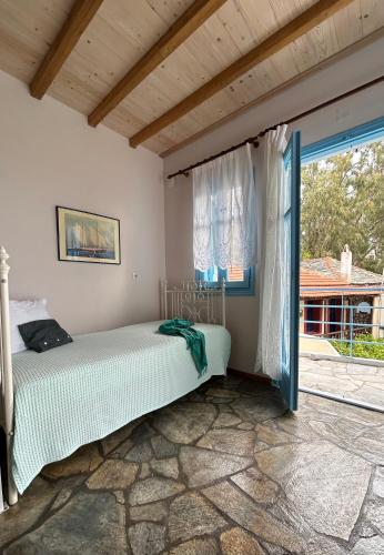 a bedroom with a bed and a window at ELECTRA TRADITIONAL HOUSE in Alonnisos