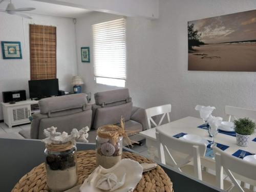 a living room with a table and a couch at KASPOZ Entire Holiday Home - Private garden & 5 mins walk to the beach in Mont Choisy