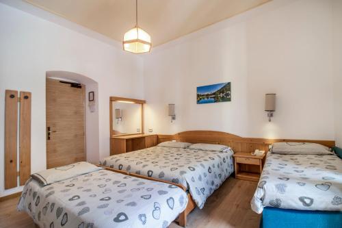 una camera d'albergo con due letti e un tavolo di Hotel Pinzolo-Dolomiti a Pinzolo