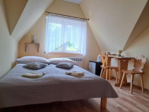 una camera da letto con un letto con due cuscini e una finestra di Pokoje "U Ani" a Leśnica
