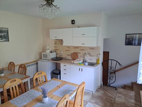 una cucina e una sala da pranzo con tavolo e sedie di Pokoje "U Ani" a Leśnica