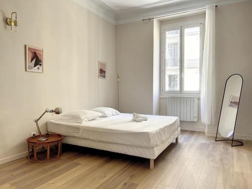 - une chambre blanche avec un lit et une fenêtre dans l'établissement Charmant appartement rénové - Central & Spacieux - Les Frères de la Loc', à Marseille