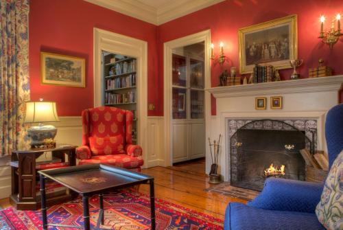 a living room with red walls and a fireplace at Francis Malbone House in Newport