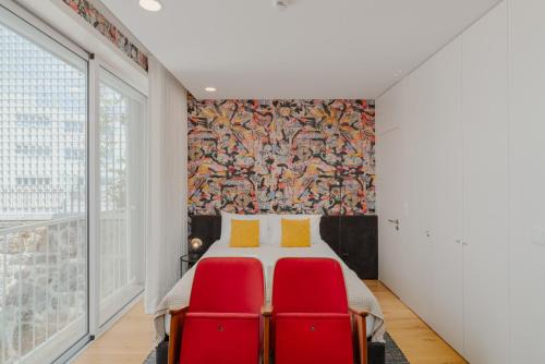 - une chambre avec un lit et deux chaises rouges dans l'établissement Theater Studio, à Porto