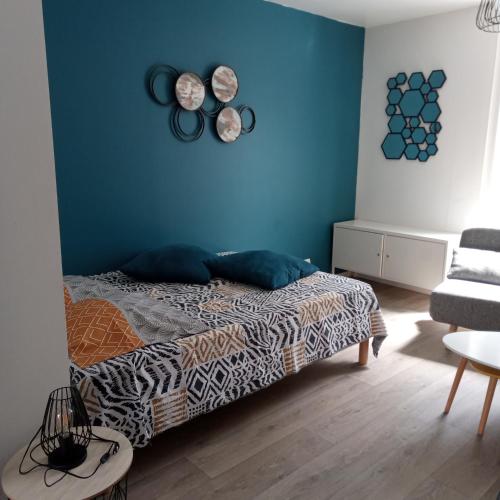 - une chambre avec un lit et un mur bleu dans l'établissement Studio Dinard, à Dinard