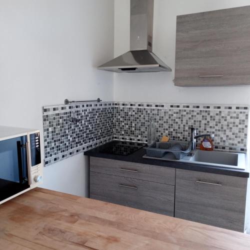 a kitchen with a sink and a microwave at Studio Dinard in Dinard