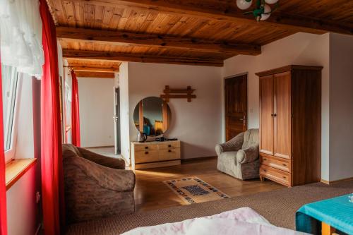 sala de estar con techo de madera y espejo en Pokoje u Małgosi, en Kosewo
