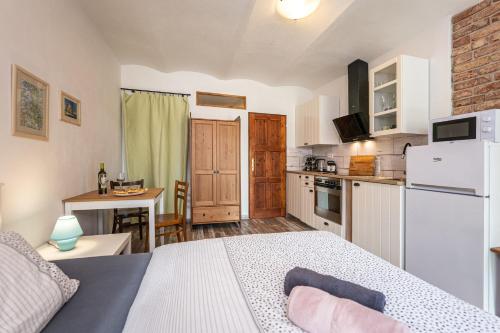 a bedroom with a bed and a kitchen with a table at Škorničkův statek in Chlum u Třeboně