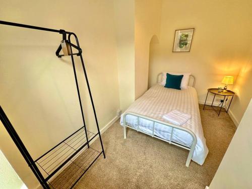 ein kleines Schlafzimmer mit einem Bett und einer Lampe in der Unterkunft EasyRest House 3 Grantham - 5 Beds & Free Parking - Easy Location - Access to A1, Town Centre & Shops in Grantham