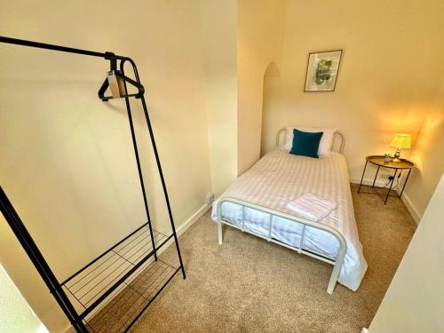 a small bedroom with a bed and a lamp at EasyRest House 3 Grantham - 5 Beds & Free Parking - Easy Location - Access to A1, Town Centre & Shops in Grantham