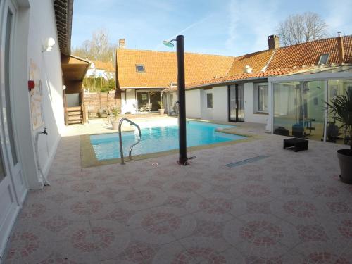a swimming pool in the courtyard of a house at Auberge du Gros Tilleul in Argoules