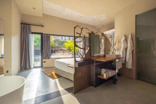 a bedroom with a bed and a tub and a sink at Hotel Viura in Villabuena de Álava