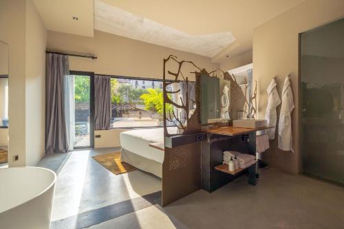 1 dormitorio con cama, bañera y lavamanos en Hotel Viura, en Villabuena de Álava