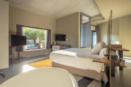 a bedroom with a large bed and a television at Hotel Viura in Villabuena de Álava