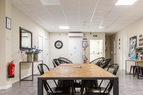 a room with a table and chairs and a fire extinguisher at Piccolo Catalunya Hostel in Alghero