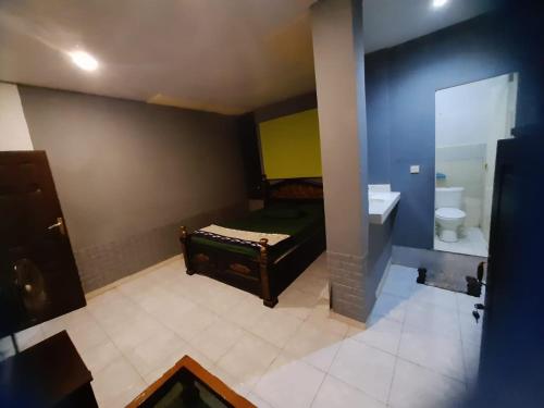 ein Bad mit einem Bett, einem WC und einem Waschbecken in der Unterkunft New KAMI Homestay in Banyuwangi