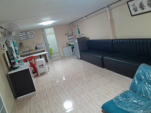 une salle d'hôpital avec un canapé et une cuisine dans l'établissement บ้านริมน้ำ โพธาราม, à Ban Khlong Ta Khot