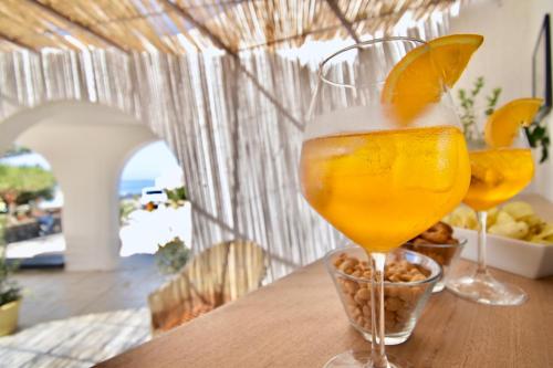 two glasses of orange juice sitting on a table at Cossyra Hotel in Pantelleria