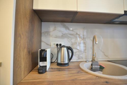 a kitchen counter with a coffee maker and a sink at Luxury Residence Mamaia in Mamaia
