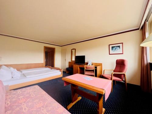 ヒンターツァルテンにあるHotel Sonnenberg Garniのベッドとデスクが備わるホテルルームです。