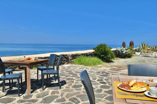 a table with a plate of food on the beach at Cossyra Hotel in Pantelleria