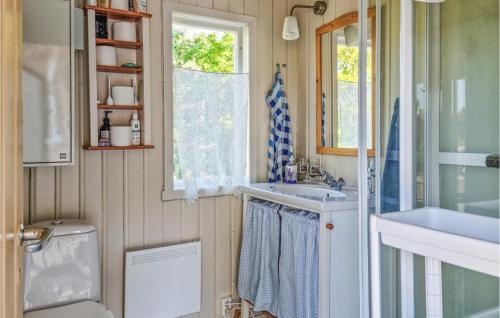 uma casa de banho com um lavatório, um WC e uma janela. em Stunning Home In Brekkest With Kitchen 