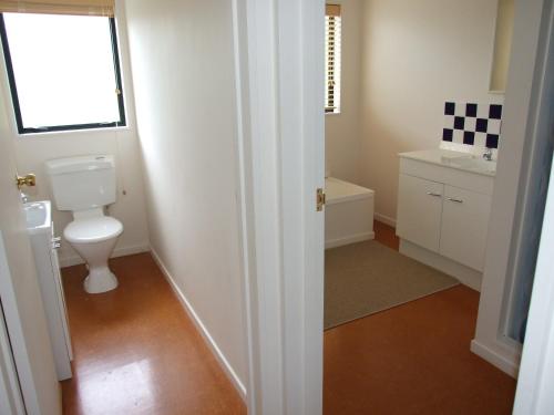 a bathroom with a white toilet and a sink at Aqua Views - Kuratau Holiday Home in Kuratau