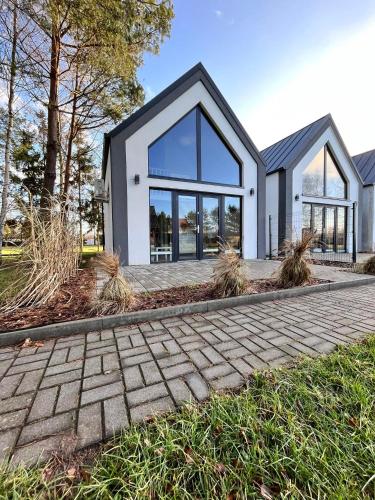 a house with large windows and a brick driveway at DOMIKO in Nickelswalde