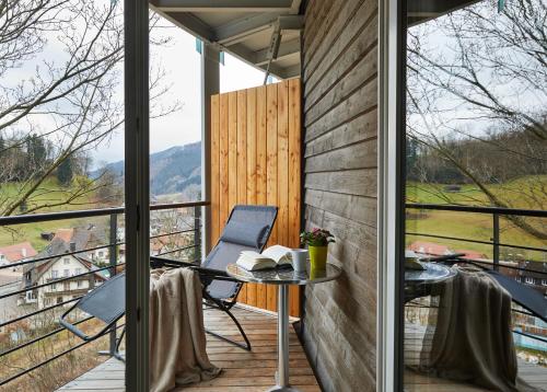 a room with a table and chairs on a balcony at ElzLand Hotel Pfauen WELLNESS & SPA in Elzach