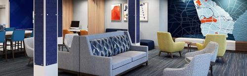 a waiting room with chairs and a table and a table and chairs at Holiday Inn Express & Suites Kernersville South by IHG in Kernersville