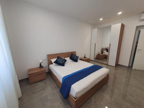a bedroom with a large bed with blue pillows at Deviveschi guest house in Castellammare di Stabia