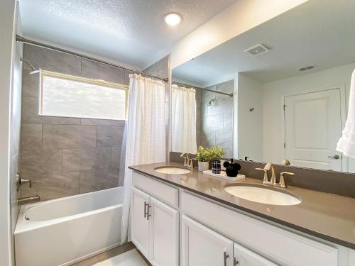 a bathroom with two sinks and a bathtub and a tub at Disney Villa w/ pool + FREE Pet Fee under 25lbs in Kissimmee