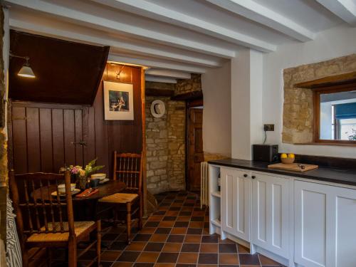 eine Küche mit Tisch und Esszimmer in der Unterkunft Armada Cottage in Charlbury