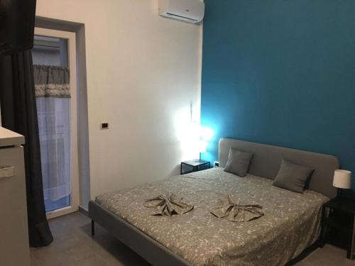una camera con un letto con una parete blu di HOLIDAY PATRIZIA'S HOME a San Giorgio Ionico