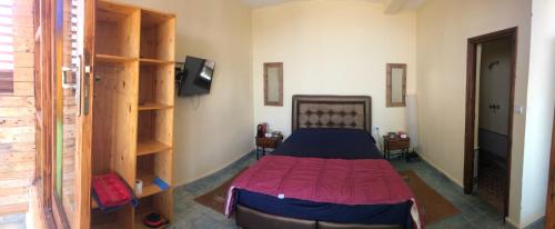 Schlafzimmer mit einem Bett mit einer roten Tagesdecke in der Unterkunft Little Paradise House in Agadir