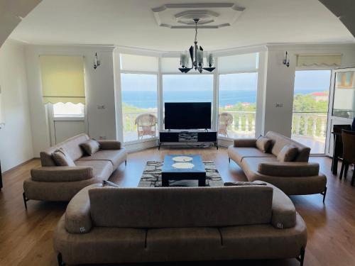 a large living room with couches and a television at Sadik Villa (Sea View 4 Bedrooms and 4 Bathrooms) in Trabzon