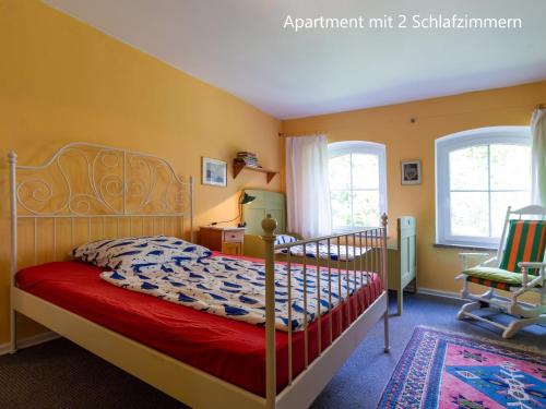 a bedroom with a bed and a chair at Ferienwohnung im Landhaus Neparmitz in Poseritz