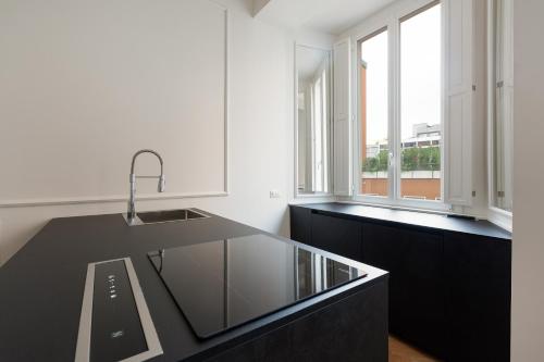 una cocina con encimera negra y fregadero en Brera Apartments in San Fermo, en Milán