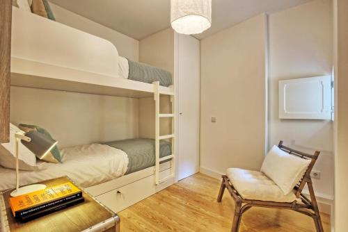 リスボンにあるApartamento espaçoso, ideal para famílias - São Bento - TTL339の小さな客室で、二段ベッドと椅子が備わります。