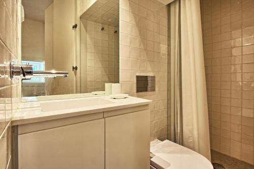 uma casa de banho com um lavatório, um WC e um espelho. em Apartamento espaçoso, ideal para famílias - São Bento - TTL339 em Lisboa