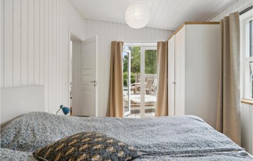 1 dormitorio con 1 cama y puerta que da a un patio en Cozy Home In Dronningmlle With Kitchen, en Dronningmølle