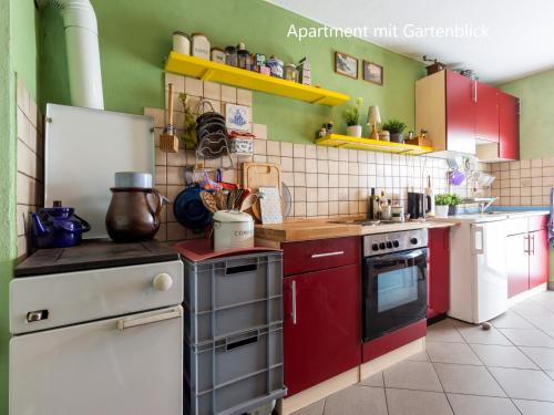 a kitchen with red and white appliances and green walls at Ferienwohnung im Landhaus Neparmitz in Poseritz