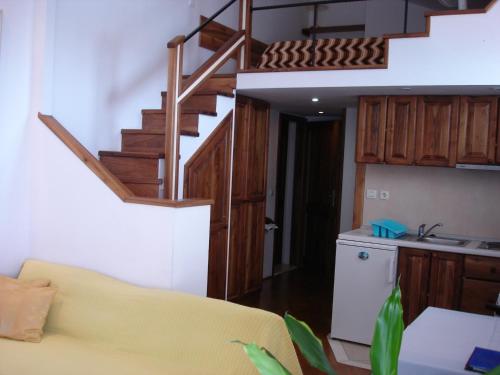 a living room with a yellow couch and a staircase at Belvedere Studio in Dubrovnik