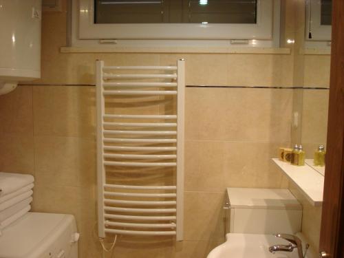 a bathroom with a toilet and a towel rack on the wall at Belvedere Studio in Dubrovnik