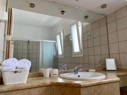 ein Bad mit einem Waschbecken und einem Spiegel in der Unterkunft Villa Sofia with garden, pool and lounge areas in Kolymbia
