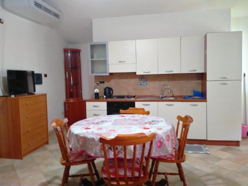 uma cozinha com uma mesa, 2 cadeiras e um frigorífico em Le Rose em Olmedo